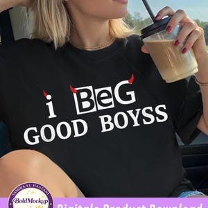 Op de afbeelding: Zwart t-shirt met de witte tekst "i BeG GOOD BOYSS", met rode duivelshoorns boven de letters "i" en "G". De afbeelding bevat ook een logo voor digitale productdownload.