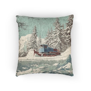 Può includere: Cuscino quadrato con una scena invernale in stile vintage. Il design presenta un gatto delle nevi blu che sgombra la neve, con pini innevati e montagne sullo sfondo. La tavolozza dei colori comprende sfumature di blu, marrone e bianco.