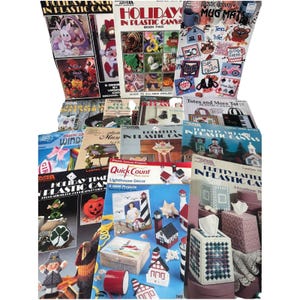May include: A collection of instructional craft booklets for plastic canvas projects, featuring various designs such as holiday decorations, lighthouse motifs, tissue box covers, and mug mats, with printed titles and colorful project illustrations.