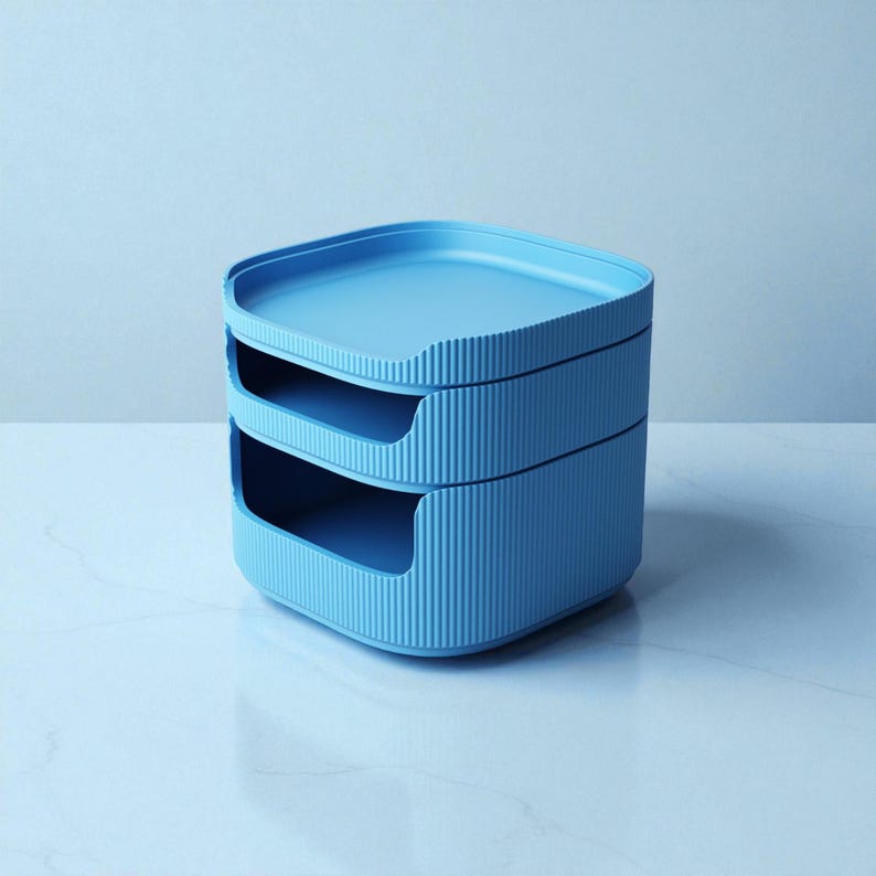 May include: A stackable, light blue storage organizer with two open compartments and a top tray. The organizer has a ribbed texture on the sides and is made of a solid, durable material. Ideal for office or home organization.