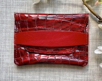 Card holder / pocket wallet in high quality red croco print patent leather with red veg tanned strap. Personalised option