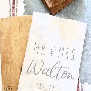 May include: White kitchen towel with the text "MR. & MRS. Walton EST. 2018" printed in gray.
