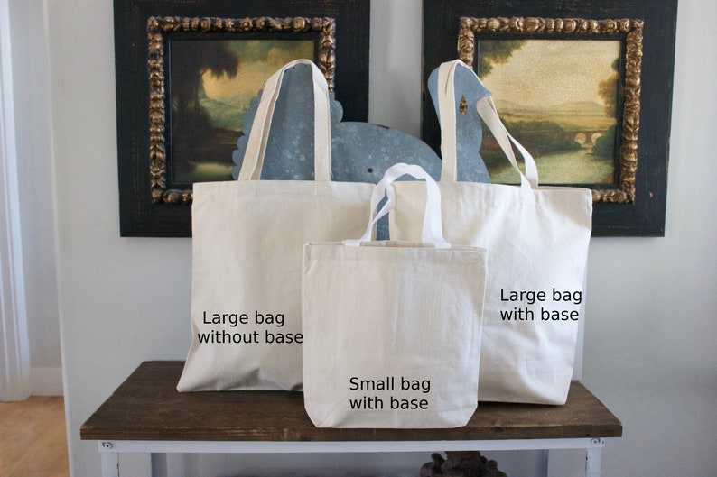 May include: Three canvas tote bags of different sizes. The largest bag is labeled "Large bag with base", the medium bag is labeled "Large bag without base", and the smallest bag is labeled "Small bag with base".
