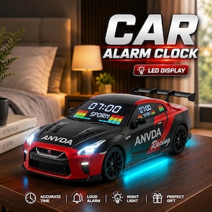 May include: A black and red sports car-shaped alarm clock with a digital LED display showing 07:00 and the text SPORN. The car features a rear spoiler, ANVDA Racing branding, and bright white headlights with blue underglow lighting effects.