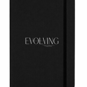 May include: A black notebook with the word "EVOLVING" in white, with the phrase "in real time" below it. The notebook has a black elastic band closure.