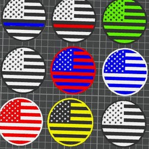 以下が含まれることがあります： さまざまな配色のアメリカ国旗が描かれた9つの丸いパッチ。デザインには、白黒、赤と黒、緑と黒、赤と青、青と白が含まれます。パッチは灰色のグリッドに表示されています。