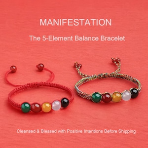 Puede incluir: Dos pulseras con cuentas de colores. Una es roja con cuentas verdes, rojas, amarillas, blancas y negras. La otra es multicolor con cuentas similares. El texto dice "MANIFESTACIÓN" y "The 5-Element Balance Bracelet."