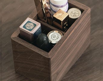 May include: A wooden makeup organizer with multiple compartments, filled with various cosmetic products. The organizer is made of dark brown wood and contains items like lipstick, compacts, and jars. The overall aesthetic is clean and organized.