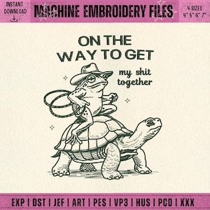 May include: Machine embroidery file design with the text "ON THE WAY TO GET my shit together". The design features a frog wearing a cowboy hat riding a turtle. Available in 4 sizes: 10 cm, 13 cm, 15 cm, and 18 cm.