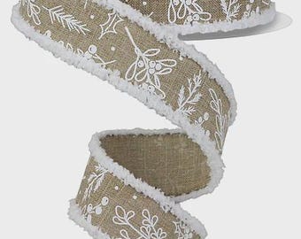May include: A spool of tan burlap ribbon featuring a white printed pattern of holly leaves, berries, and pine branches. The ribbon edges are finished with a white frayed, fuzzy texture, creating a distinct contrast against the natural fabric.