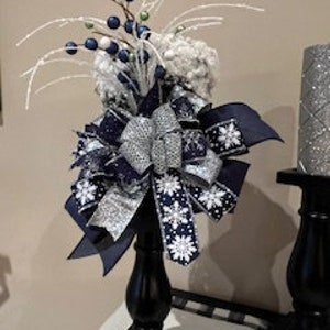 Navy and silver Christmas tree topper snowy rattan top hat with navy silver ribbon and white glittered stems with navy and green berries