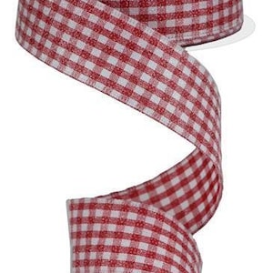 Può includere: Una bobina di nastro a quadretti rossi e bianchi. Il nastro è srotolato, mostrando il motivo a quadretti rossi e bianchi. La bobina è bianca.