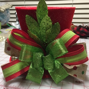 Christmas tree topper top hat red with lime green bay leaves About to run out of red and lime ribbon. Will need to substitute but same color