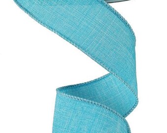 Puede incluir: Un rollo de cinta de arpillera azul turquesa con borde de alambre. La cinta tiene 2,5 pulgadas de ancho y un aspecto texturizado y tejido.
