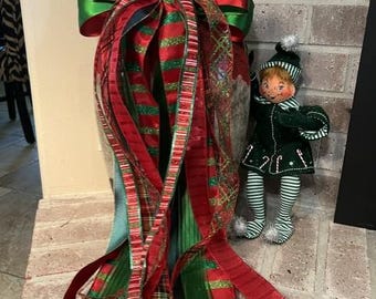 Kerstkrans met rode en groene omkeerbare satijnen strik met grote knopen en ijzerdraad, geschikt voor lantaarns.