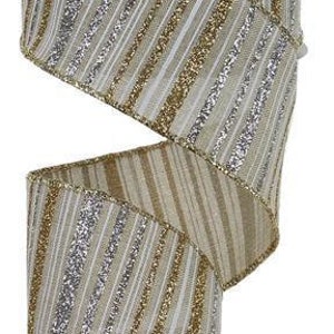 Könnte beinhalten: Eine Rolle 2,5 Zoll breites, drahtverstärktes Band mit einem beige, gold und silber gestreiften Muster. Das Band hat eine schimmernde Oberfläche.