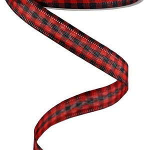 May include: Red and black buffalo plaid ribbon. The ribbon is curled and has a white spool in the background.