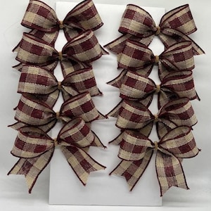May include: Set of 10 brown and cream gingham bows. The bows are tied with twine and are perfect for adding a touch of rustic charm to your home decor.
