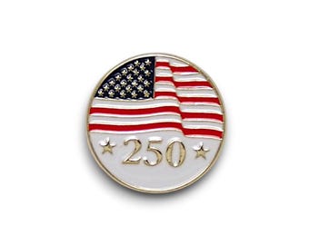 Puede incluir: Un pin redondo plateado con el diseño de la bandera estadounidense. La bandera es roja, blanca y azul, con las estrellas y las rayas visibles. El número "250" se muestra debajo de la bandera, con una estrella a cada lado.