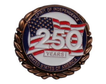 Puede incluir: Un pin redondo con borde color bronce y fondo blanco. Presenta una bandera estadounidense ondeando, el número "250" en blanco y las palabras "Spirit of Independence" y "United States of America".