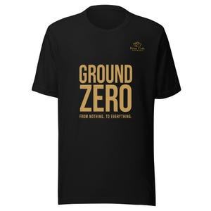 May include: Black t-shirt with the words "GROUND ZERO" in a gold color, with the phrase "FROM NOTHING. TO EVERYTHING." below. The Bear Cub Apparel logo is in gold on the upper right.