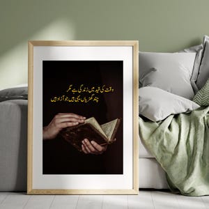 Puede incluir: Una impresión enmarcada con una imagen oscura de un libro abierto y envejecido sostenido por manos. El texto de la imagen está en un idioma extranjero, escrito en oro. El marco es de color madera clara y el fondo es verde apagado.