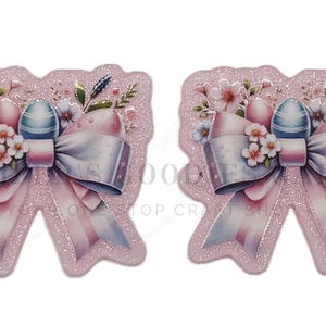 May include: Two pink glittery Easter-themed embellishments. Each features a large bow with pink and white stripes, decorated with flowers, eggs, and a blue and white egg. The background is a pink glittery shape.