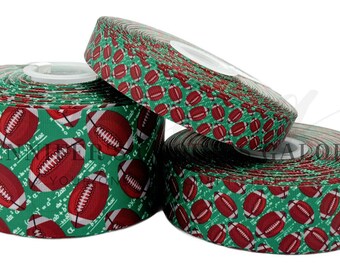 May include: Green and red ribbon with a football pattern. The ribbon has a white background with a green and red football pattern. The ribbon is rolled up and ready to be used for crafts or decorations.
