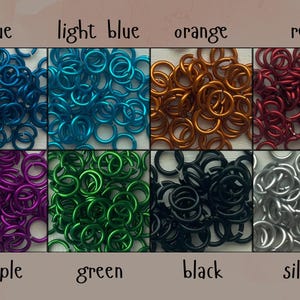 May include: A collection of colorful metal jump rings in blue, light blue, orange, red, purple, green, black, and silver. Each color is displayed in a separate square, with the color name written below each square.
