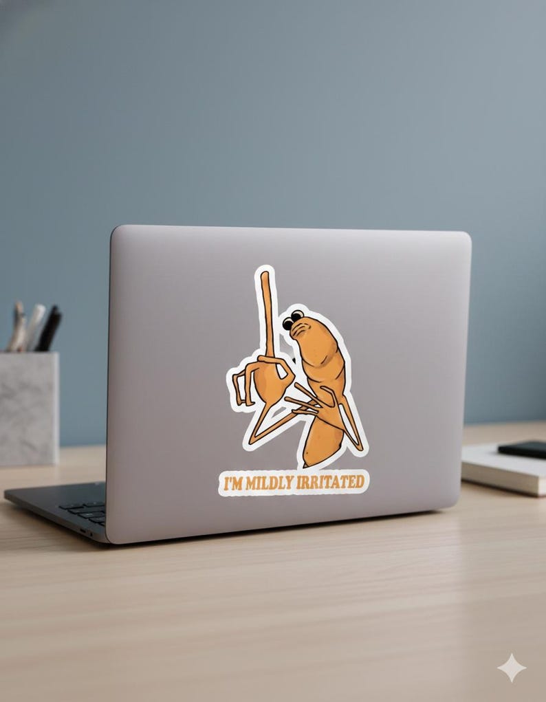 May include: A sticker featuring a cartoon character in shades of orange and brown, with the text "I'M MILDLY IRRITATED". The character is depicted with a frustrated expression and raised arms, suggesting annoyance.