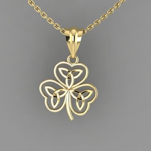 May include: A gold-colored pendant necklace featuring a Celtic knot shamrock design. The pendant is a three-leaf clover shape with intricate knotwork. The chain and pendant are a bright, shiny gold color, set against a gray background.