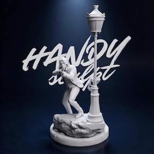 May include: A white sculpture of a person aiming a gun, standing on a rock next to a street lamp. The sculpture has the text "HANDY sculpt" in white cursive. The background is a dark blue.