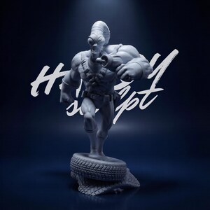 Pode incluir: Estatueta cinzenta de um personagem alienígena musculoso, em pose de corrida, com uma arma na mão. A figura é montada em um pneu e uma base texturizada. O fundo é azul escuro com texto branco "Happy Concept".