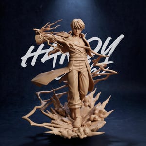 Peut inclure: Figurine beige d'un personnage masculin en pose dynamique, avec des cheveux et des vêtements fluides. La figurine est sur une base texturée avec des effets d'énergie stylisés. Le fond est bleu foncé avec du texte blanc.