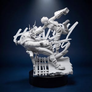 May include: A white figurine depicting a dynamic action scene with two figures in combat. One figure is leaping, while the other is seated. The word "HEAVY" is written in a stylized font. The base is black.