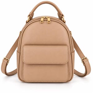 Puede incluir: Una mochila pequeña de color beige con acabado liso y mate, asa superior y correas ajustables. El bolso incluye un compartimento principal con cremallera y dos tiradores de metal dorado, además de un bolsillo frontal con cierre de solapa.