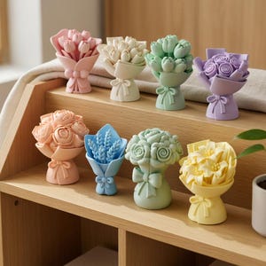 Puede incluir: Una colección de pequeños ramos de flores coloridas en varios tonos pastel. Cada ramo está envuelto y atado con una cinta. Las flores incluyen rosas, tulipanes y otros arreglos florales. Los ramos se exhiben en una estantería de madera.