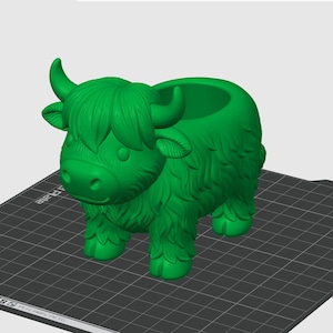 May include: A green Highland cow planter with a detailed, textured design. The planter has a round opening on its back for plants. The cow has horns, a fluffy mane, and a friendly face. The planter is a decorative item.