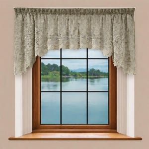 Puede incluir: Un visillo de ventana de encaje beige con un borde inferior festoneado se muestra sobre una ventana. La ventana tiene un marco de madera y una vista de un cuerpo de agua y árboles. El visillo está recogido en la parte superior.