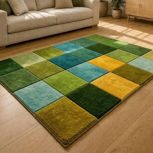 May include: A colorful area rug with a geometric pattern of squares in shades of green, blue, and yellow. The rug is placed on a hardwood floor in a living room setting, with a beige sofa and neutral-toned decor in the background.
