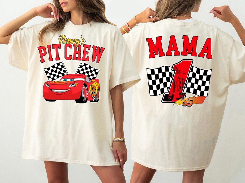 Pu&ograve; includere: T-shirt color crema con grafica di auto da corsa rossa e la scritta "Henry's Pit Crew" sul davanti. Il retro della maglietta mostra la parola "MAMA" e un numero di gara.