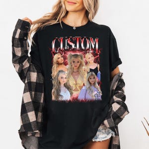 Puede incluir: Camiseta negra de manga larga con un dise&ntilde;o gr&aacute;fico. El dise&ntilde;o presenta la palabra "CUSTOM" en rojo y blanco, con im&aacute;genes de una mujer rubia y un efecto de rayo rojo. La camiseta la lleva una persona.