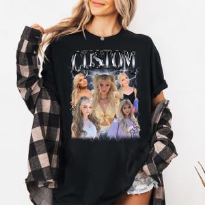 Puede incluir: Camiseta negra con un dise&ntilde;o gr&aacute;fico que presenta la palabra "CUSTOM" en una fuente plateada estilizada. El dise&ntilde;o incluye m&uacute;ltiples im&aacute;genes de una mujer rubia. La camiseta la lleva una persona que lleva una camisa a cuadros negra y marr&oacute;n.