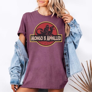Peut inclure: T-shirt bordeaux avec un motif &laquo; MONGO IS APPALLED &raquo; en jaune et noir. Le motif comprend une silhouette de cr&eacute;ature et un dinosaure. Le t-shirt est &agrave; manches courtes et &agrave; col rond.