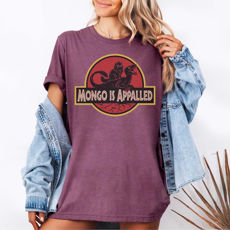 Peut inclure: T-shirt bordeaux avec un motif &laquo; MONGO IS APPALLED &raquo; en jaune et noir. Le motif comprend une silhouette de cr&eacute;ature et un dinosaure. Le t-shirt est &agrave; manches courtes et &agrave; col rond.