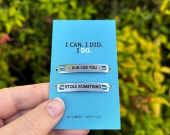 May include: A blue card with the text "I CAN. I DID. I DO." and the phrases "RUN LIKE YOU" and "STOLE SOMETHING" on silver metal bars. The card also reads "NO LIMITS - JUST YOU".