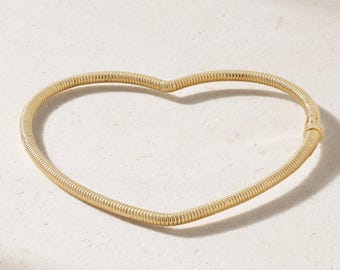 Pulseira delicada em ouro maciço 14K com formato de coração torcido.