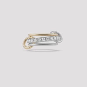 May include: A multi-tone ring featuring a gold band, a silver band, and a band with small, clear gemstones. The ring has a unique interlocking design, with the bands overlapping and connecting. The ring is set against a light background.