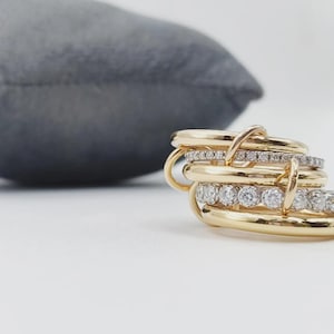 Könnte beinhalten: Ein Set aus drei Keramikbechern mit gesprenkelter, matter Oberfläche. Die Becher sind in den Farbtönen Creme, Hellgrau und Dunkelgrau gehalten. Jeder Becher hat ein schlichtes, minimalistisches Design und einen abgerundeten Henkel.