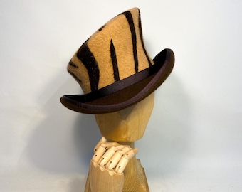 May include: A brown and tan striped top hat with a brown brim. The hat is on a wooden hat stand.